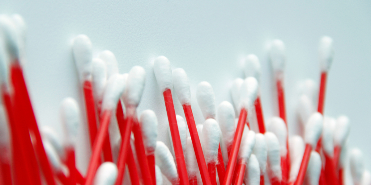 plastic Cotton swabs, red plastic cotton swabs on a light blue grey background