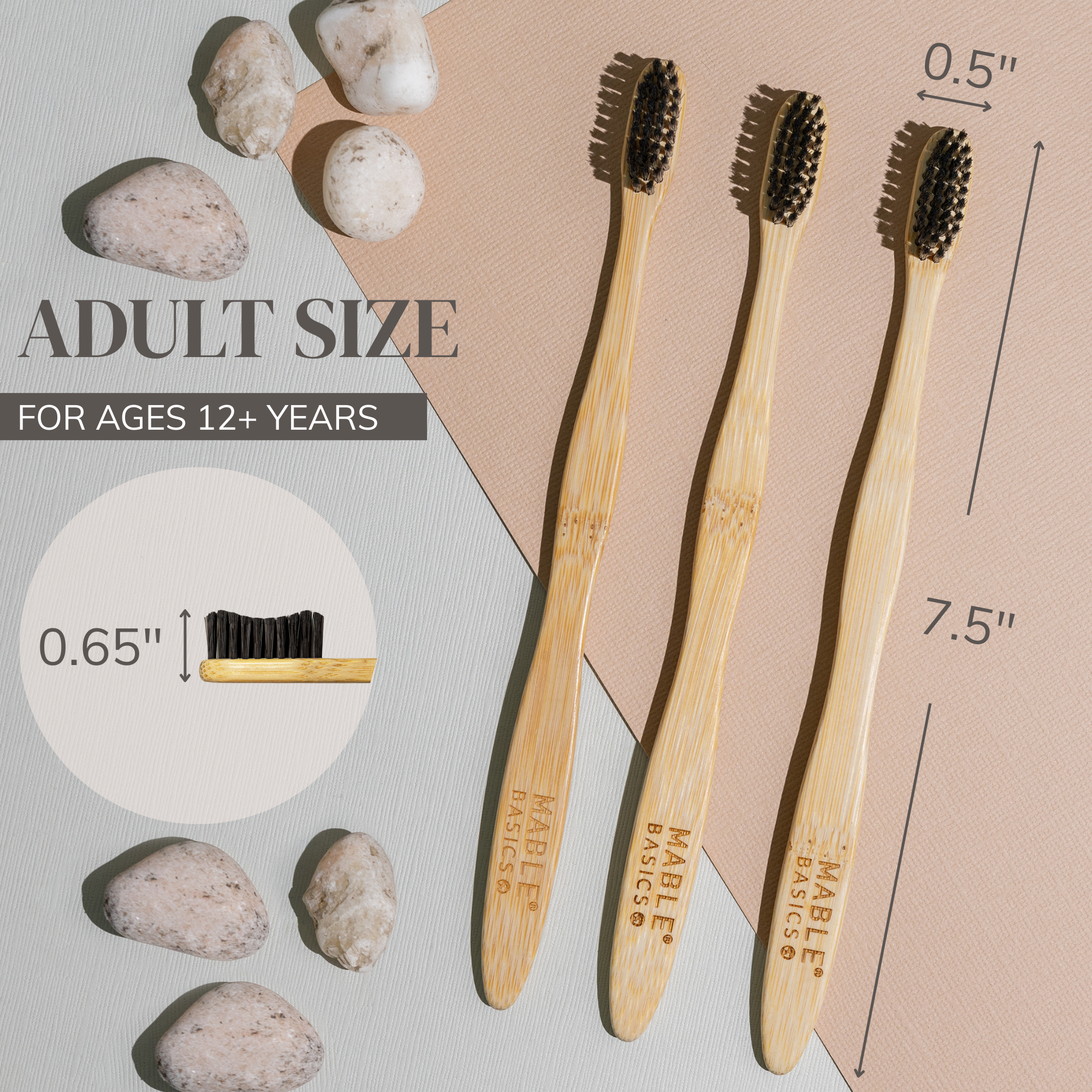 Three MABLE bamboo toothbrushes with measurements and rock stones on a neutral background