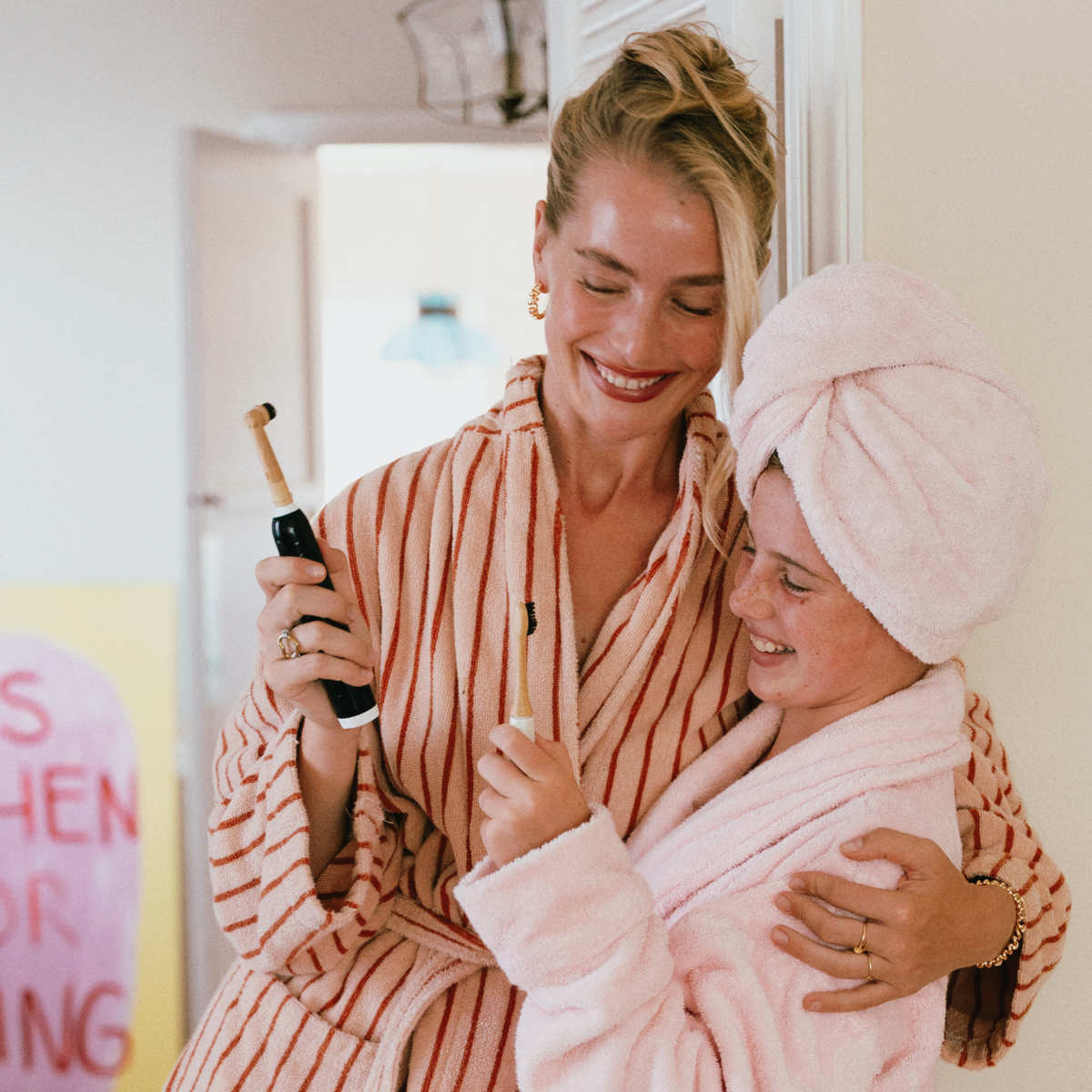 Natural Oral_b electric heads made from Bamboo by MABLE Brush, mother showing daughter her eco electric head in a bathroom robe