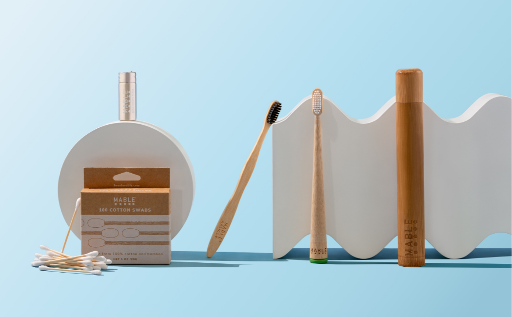 MABLE Bamboo toothbrushes, refillable dental floss, bamboo cotton swabs, bamboo toothbrush travel case with plastic-free packaging on a light blue background