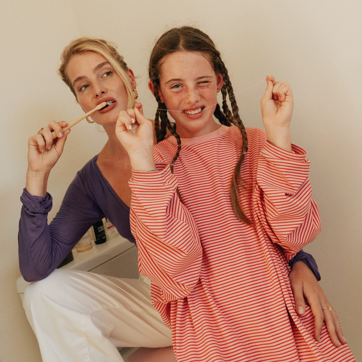 Mother and daughter using eco-friendly floss and bamboo toothbrush by MABLE