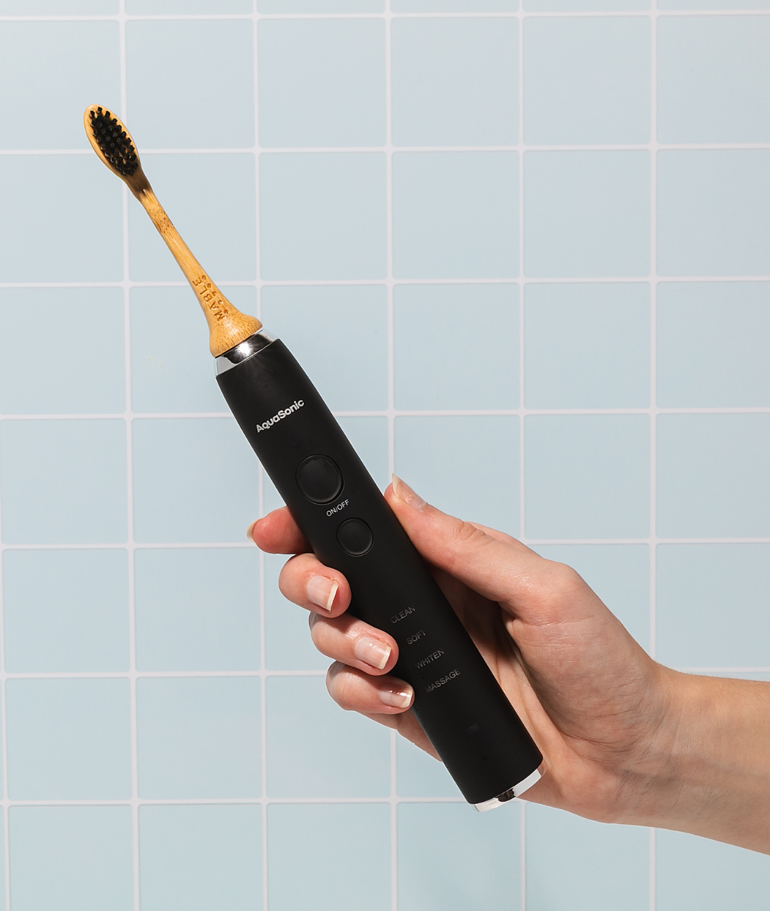 The best bamboo electric toothbrush heads by MABLE, persons hand holding an AquaSonic electric toothbrush with a MABLE bamboo electric head