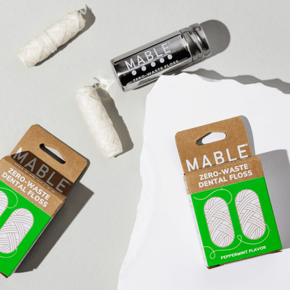 MABLE dental floss in a stainless steel refillable dental floss container pictured with eco-freindly dental floss refills made from natural ingredients