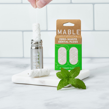 MABLE silk dental floss two pack packaging with the refillable silk dental floss container with a marble and white titiled background