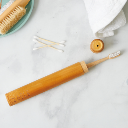 MABLE toothbrush travel container with Bamboo toothbrush with wooden handle on a marble surface